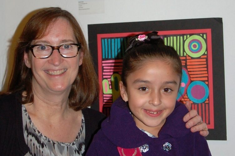 Natalia and Mrs. Kendell pose by her artwork.