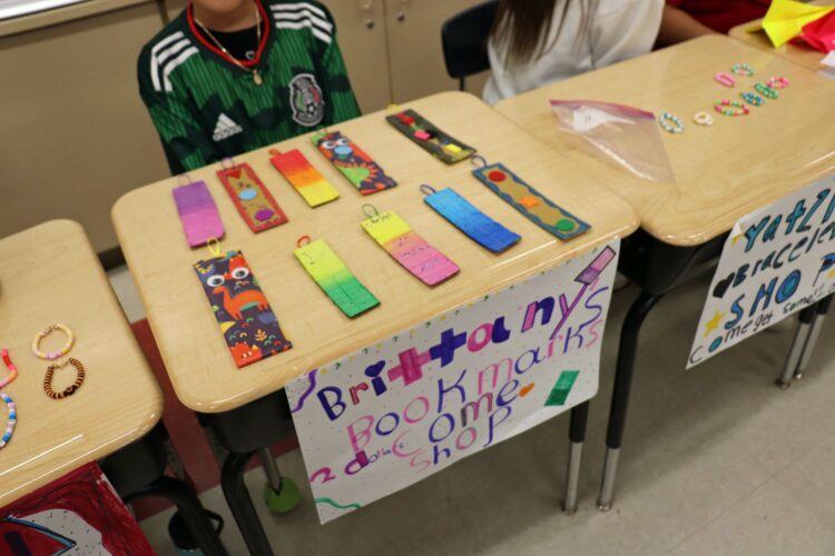 A student shows off her bookmarks to sell.