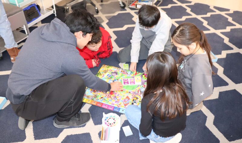 Mr. Hernandez teaches 4th graders the rules of the game "Life".