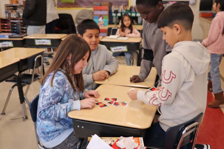 4th graders playing a game of Uno.