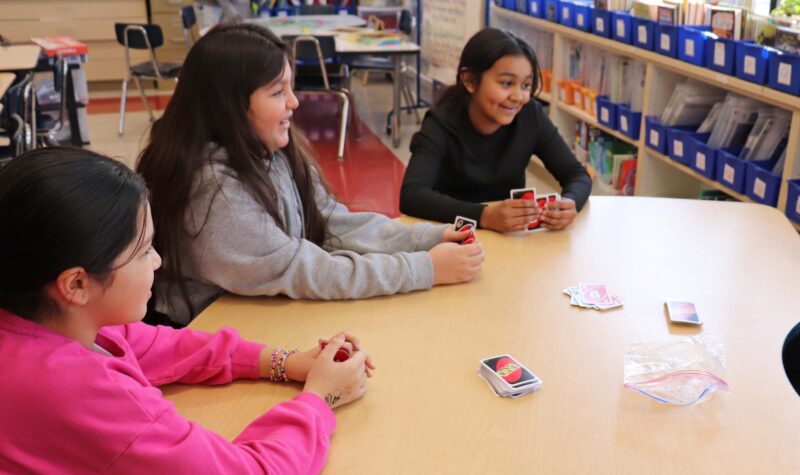 4th grade girls play a game of Uno.