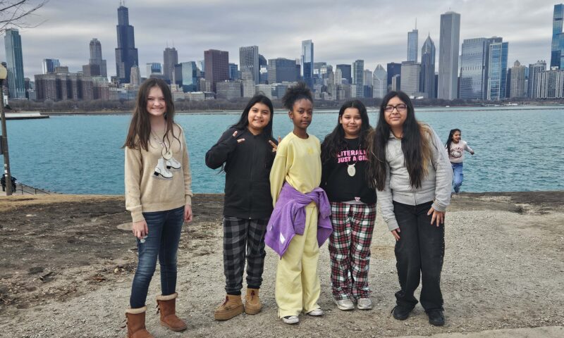 Students pose by the Chicago skyline outside the Adler Planetarium.